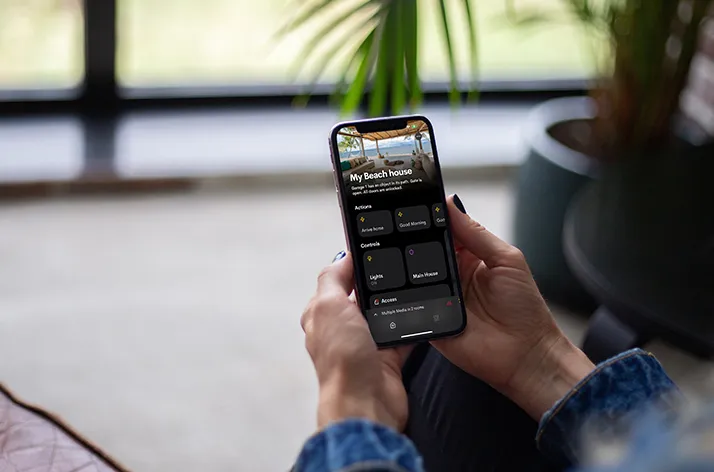 User managing a smart home control system through a smartphone app.