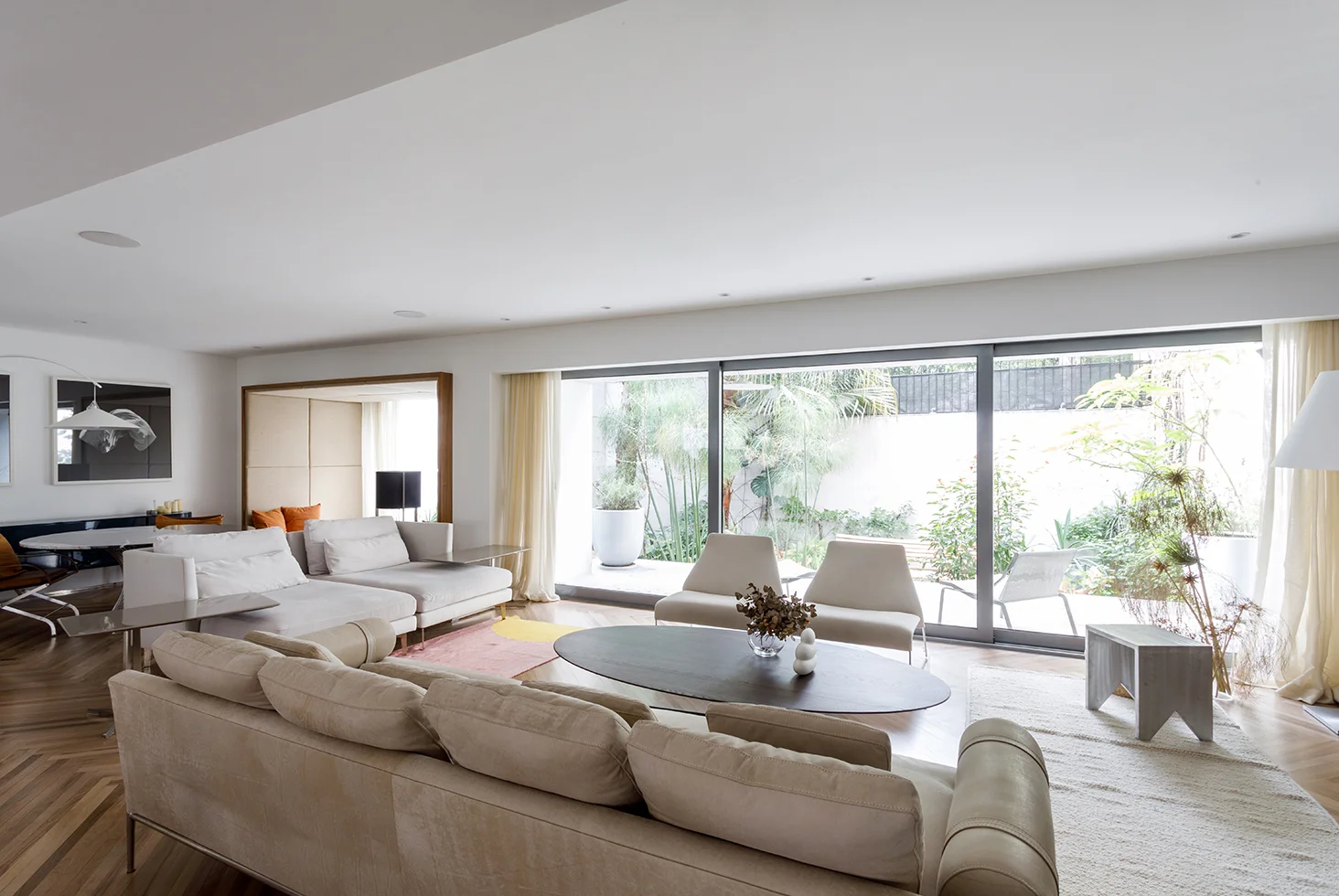 Living room at Casa Castex with sofas, large windows and garden view.