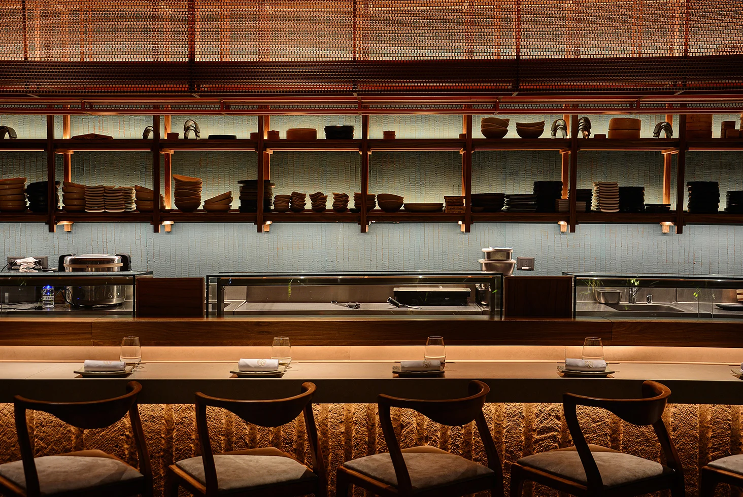 Interior sushi bar counter with wooden shelves at Osaka Sushi Rest.